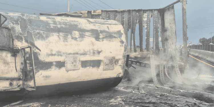explosion-de-pipa-en-tlaxcala - PUNTO DE ENCUENTRO Burned-out semi-truck and trailer on a highway, with a charred exterior and rising smoke